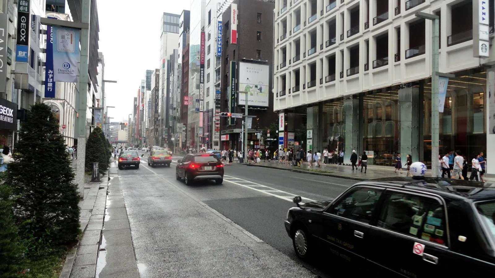 Chuo-dori, the main shopping avenue of Ginza, with shoppers on the pavement and cars on the road