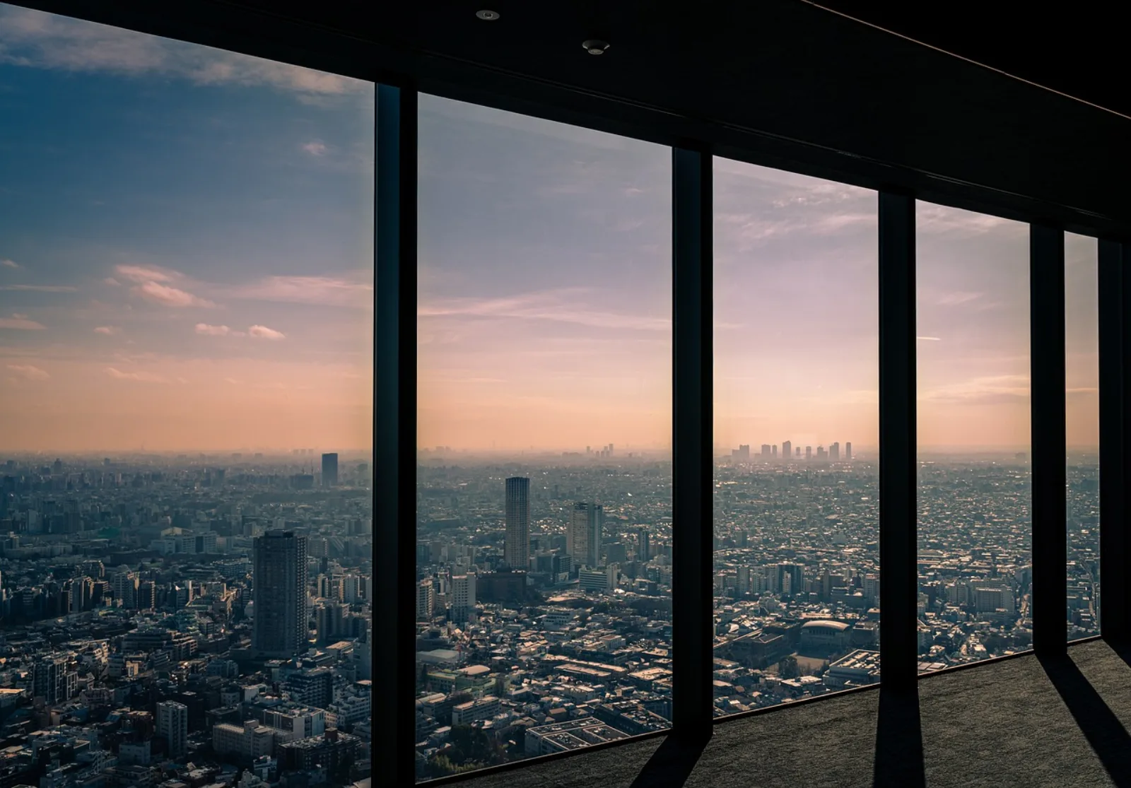 The Tokyo skyline at dusk seen through the windows of Shibuya Sky
